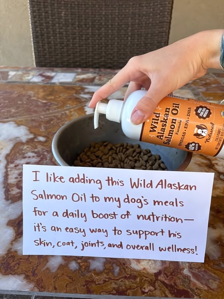 A close-up shot showing a hand adding supplement oil to dry kibble, accompanied by a handwritten-style note detailing product benefits.
